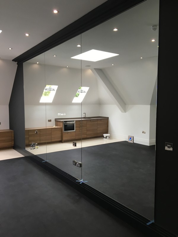 Frameless glass partition in loft conversion by Reading glaziers