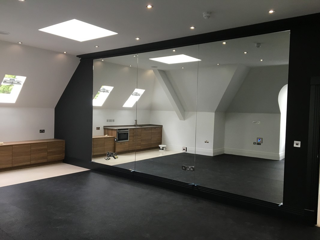 Frameless glass wall dividing loft conversion in Reading
